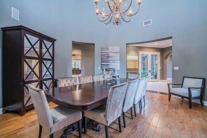 The dining room looks simple with its hardwood flooring and dining set