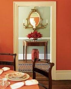 Wooden dining  table and chairs combine with chandelier and red rose on the table makes  this