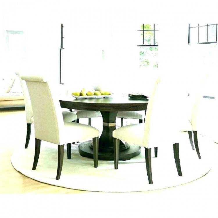 The dining room boasts an oval dining set with classy seats lighted by a chandelier