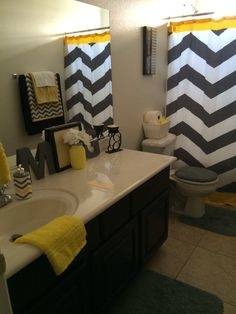 Gray and yellow chevron stripes create a a stylish accent wall in the bathroom