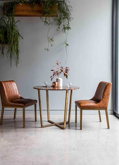 table against the wall, two chairs, one bench seat