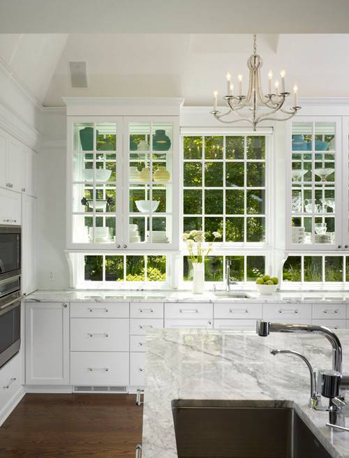 stove under window stainless steel with shelf big refrigerator window beside island beige marble white cabinets