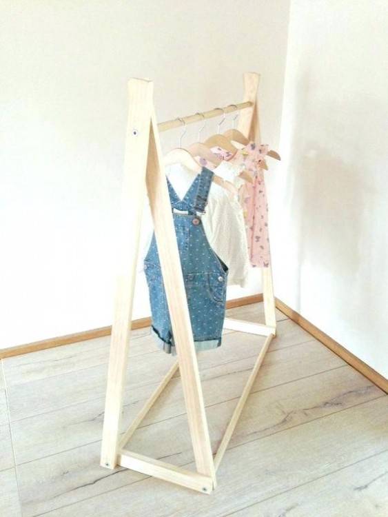 Clothing for a little girl on a clothes rack in a wardrobe