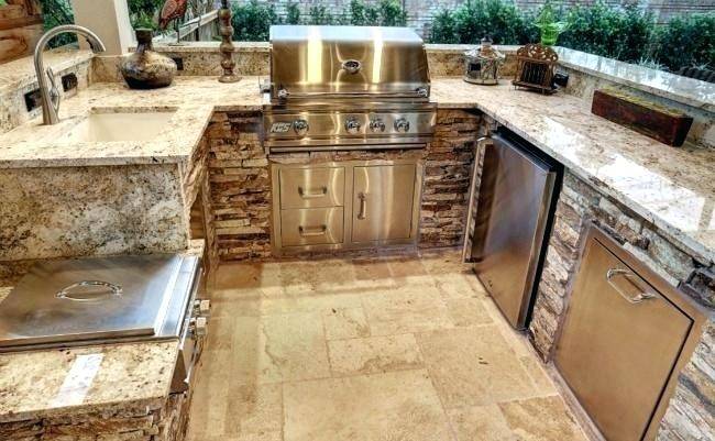 Amazing kitchen features white cabinets paired with Taj Mahal Quartzite  countertops and a white subway tiled backsplash