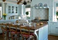 Beautiful marble and white cabinets are positioned around a  blue island